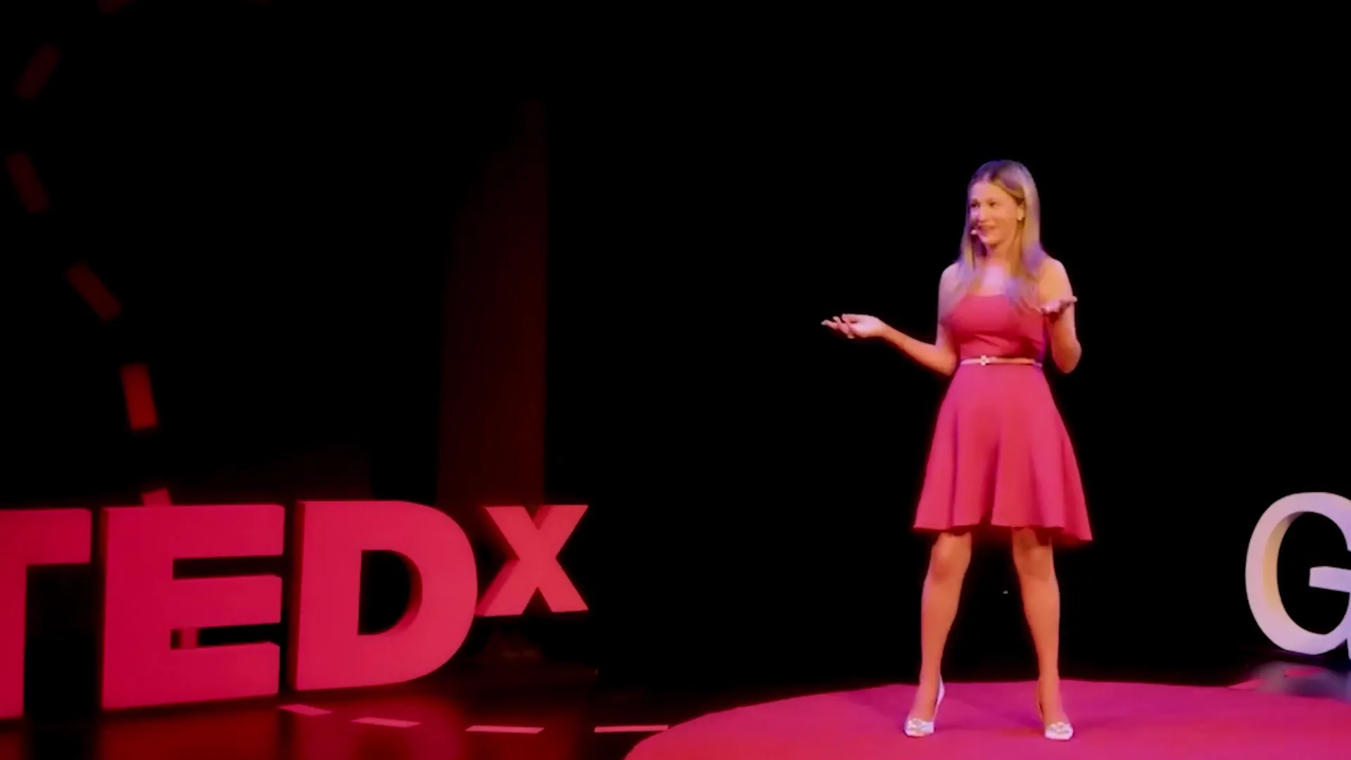 Maryann on the red circle of a TEDx stage
